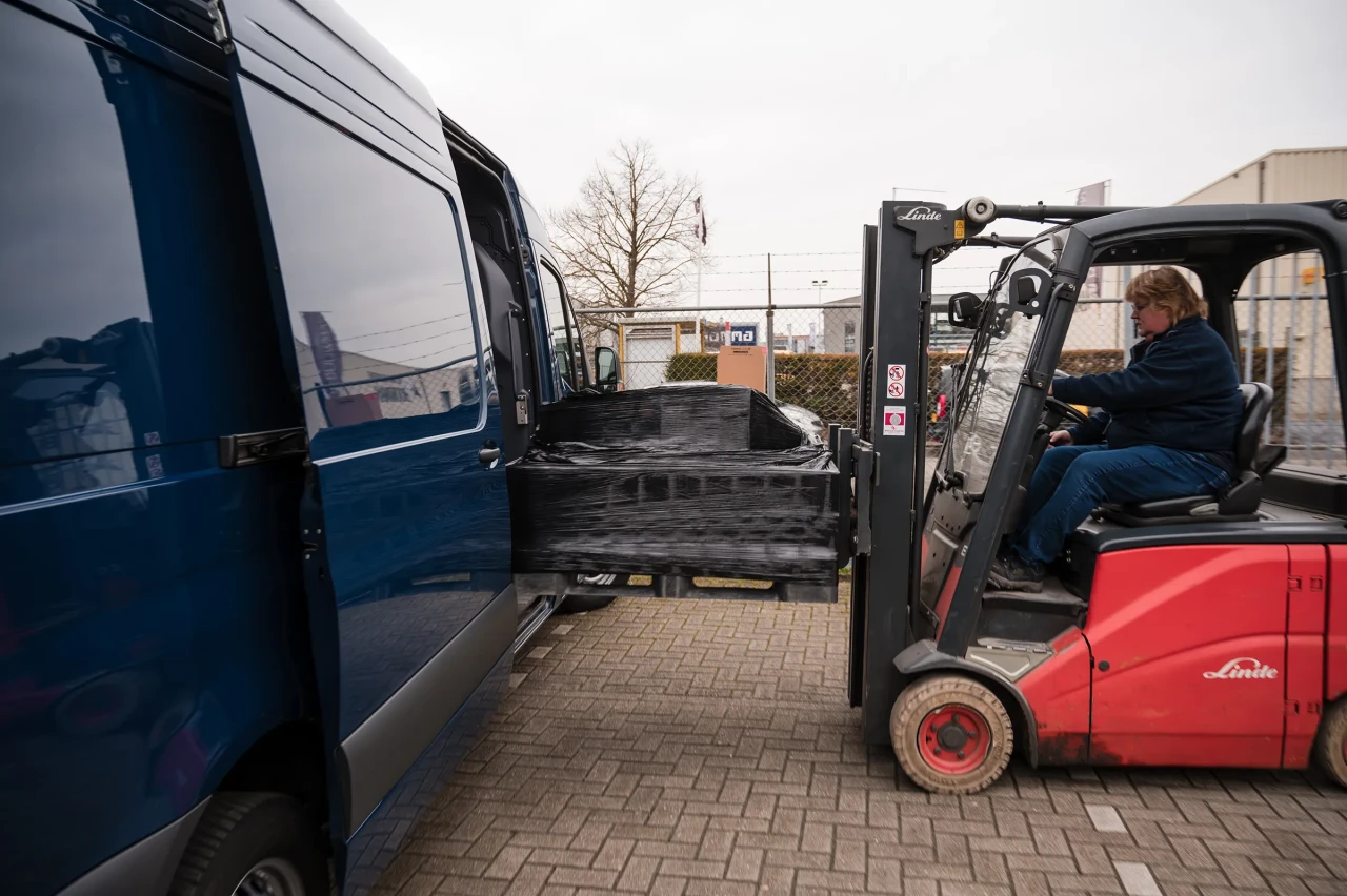 An Imatech employee operates a forklift to load a wrapped shipment into a delivery van at the company’s warehouse yard.