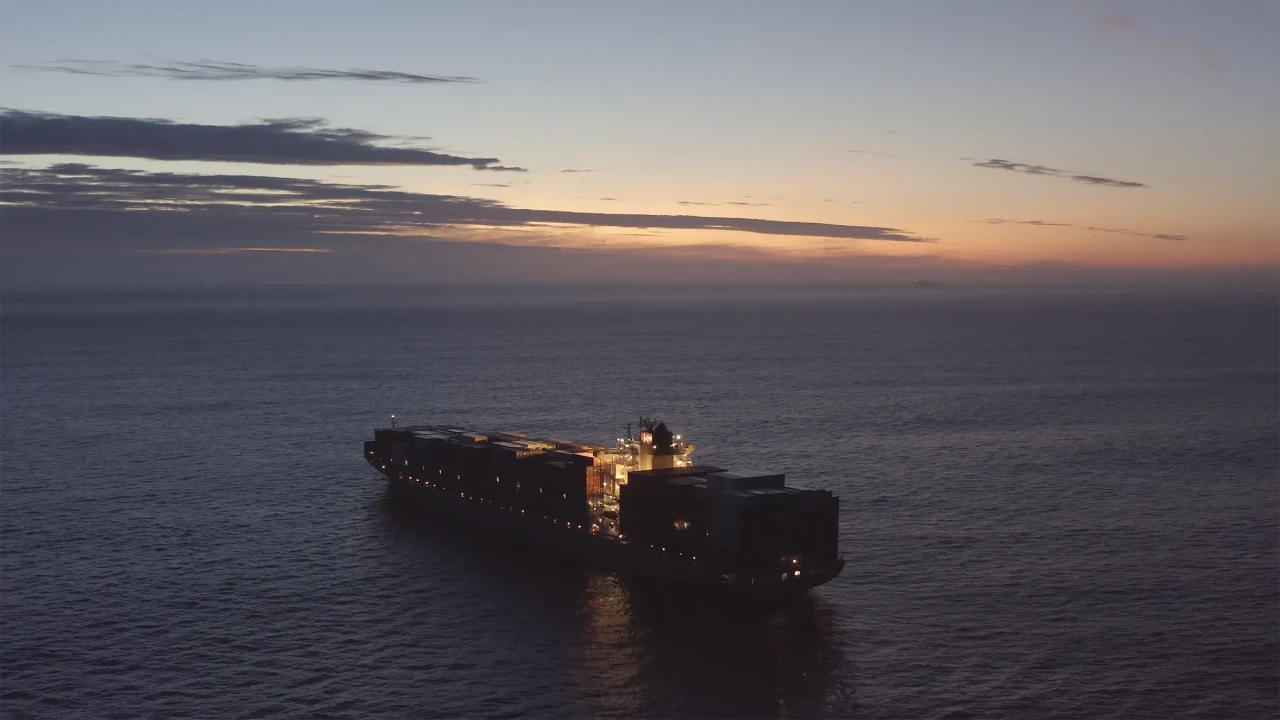 drone footage of a container ship on the ocean at sunset